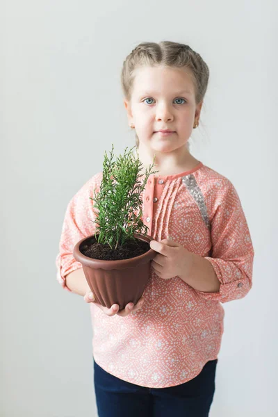 Criança bonito segurando uma planta em vaso — Fotografia de Stock