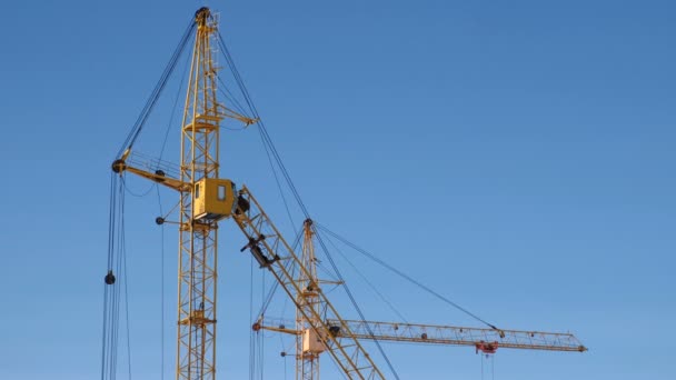 Two construction cranes against the sky background. — Stock Video