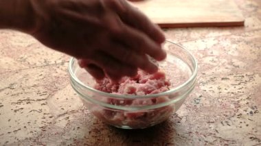 Close-Up eller olun pirzola kıyılmış et mans. Şeffaf plaka mutfak masasının üzerinde.