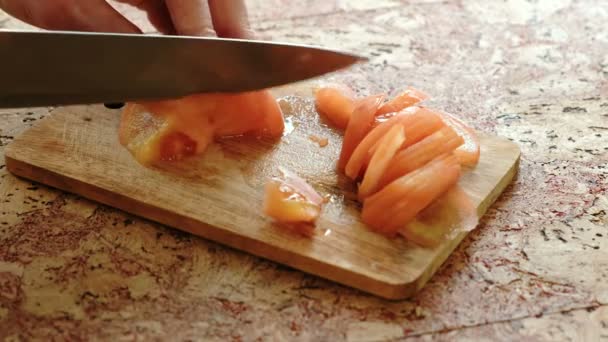 Yakın çekim domates mutfak masası ahşap bir yönetim kurulu kesim eller mans. — Stok video