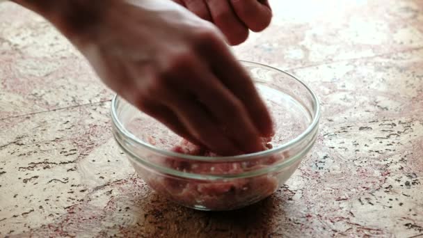 Close-up van mans handen maken schnitzels van gehakt vlees. Transparante plaat op de keukentafel. — Stockvideo