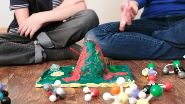 Maman et fils mains font l'expérience avec le volcan de plasticine à la maison. Réaction chimique avec émission de gaz . — Video