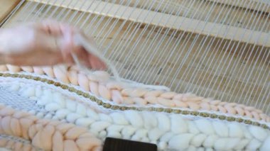 Tezgâh üzerinde dokuma. Tezgâh üzerinde çalışan kadının eller. İpliklerini iğne threading çerçeve ve tarak ile iplik tutturmak.