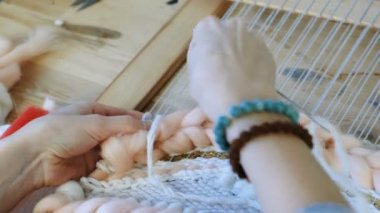 Tezgâh üzerinde dokuma. Tezgâh üzerinde dokuma. Tezgâh üzerinde çalışan kadının eller. Çerçeve ipliklerini iğne threading