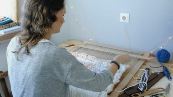 Tissage sur un métier à tisser. Jeune femme courant sur un métier à tisser. Vue arrière . — Video