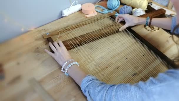 Weven op een weefgetouw frame. Closeup dames handen voorbereiden loom frame te weven. — Stockvideo