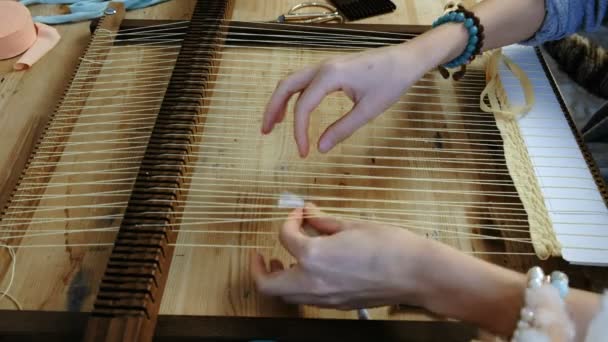 Le mani di donne di primo piano che tessono su una struttura di telaio. Vista laterale . — Video Stock