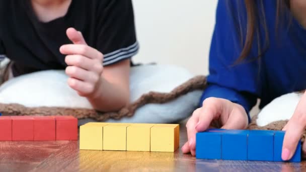 Primeros planos mamá e hijos manos la construcción de cajas de cubos de colores y bloques — Vídeos de Stock