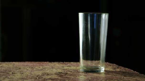 Koolzuurhoudende frisdrank drinken, gele in kleur en gegoten in een glas op een zwarte achtergrond. — Stockvideo