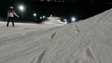 Erkek snowboard yamaç Asansörün yanında dağdan aşağı gider. Akşam snowboard.