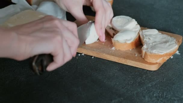 Close-up van de handen van de dames knippen van het ei en zet het op brood en boter. Een sandwich maken. — Stockvideo