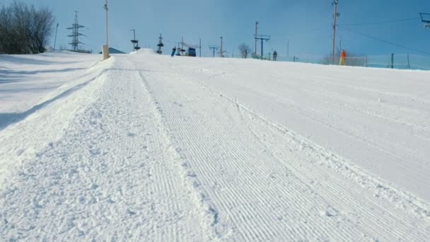 Adolescente de 12 anos deslizando em um snowboard de descida de neve próximo céu levantar e cai . — Vídeo de Stock