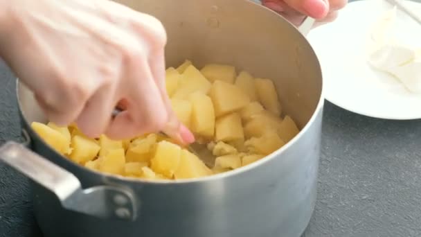 Closeup womans hand aardappelpuree vork gebruiken in pan maken. Koken van aardappelpuree. — Stockvideo