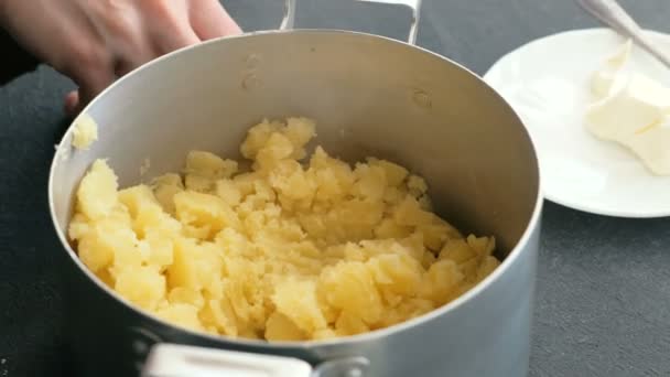 Gros plan womans main faire purée de pommes de terre, ajouter du beurre et du sel et mélanger. Cuisson des pommes de terre en purée . — Video