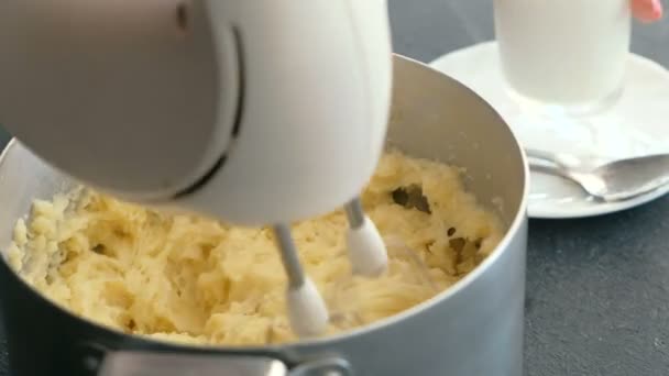 Närbild kvinnans hand att göra potatismos med mixer i kastrull. Matlagning potatismos. — Stockvideo