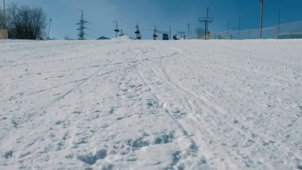 12-jähriger Junge in grauem Tuch rutscht auf Snowboard von Schneebretter-Abfahrt im Stadtpark.