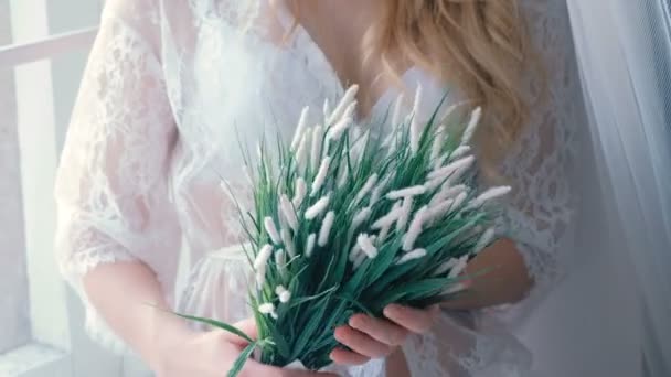 인식할 수 없는 젊은 슬림 섹시 한 금발의 여자 란제리에 내실 창턱에 lookingin 그녀의 손에 있는 인공 꽃에 앉아. — 비디오
