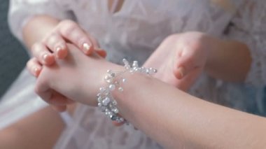 İki genç ince seksi sarışın kız iç çamaşırı ve oturma ve inci takı, seyir boudoir. Kadının eller.