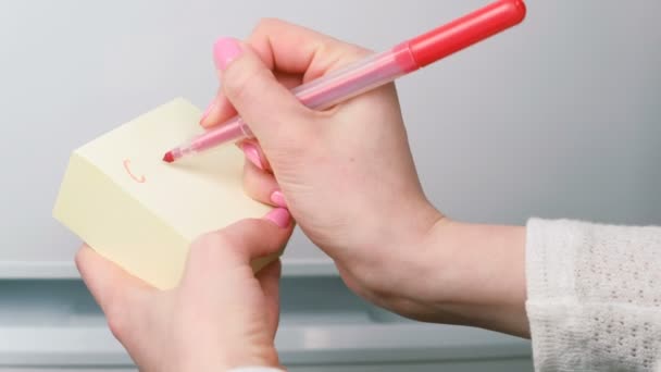 Primeros planos mujeres manos escribir en hojas de papel adhesivo amarillo palabras me llaman y pintar un corazón . — Vídeos de Stock