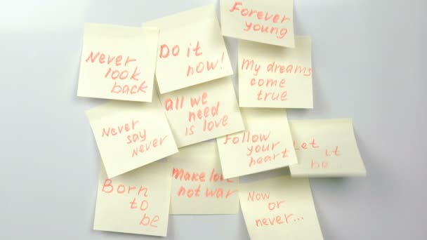 Phrases de motivation sur des feuilles de papier autocollant jaune sur un tableau blanc . — Video