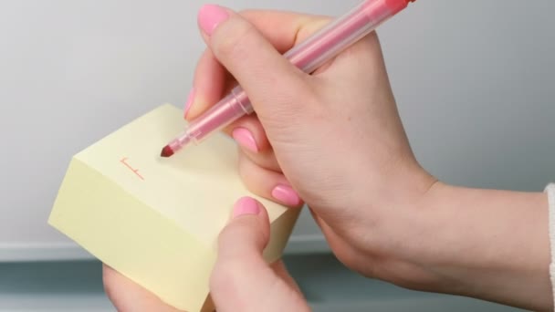 Gros plan womans mains écrire sur jaune autocollant feuilles de papier mots baise vous . — Video