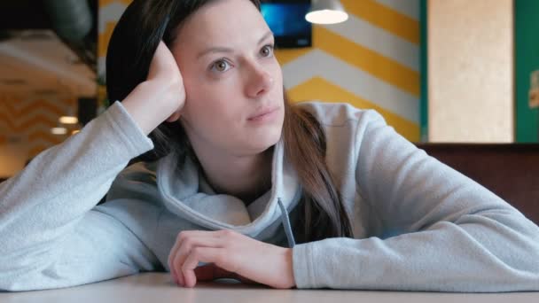 Treurige vrouw zitten in een cafe en haar bestelling wachten. Closeup. — Stockvideo