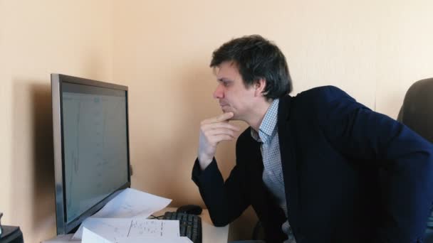 Giovane uomo sta lavorando sodo dietro il computer . — Video Stock