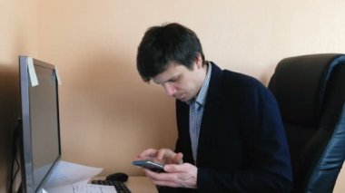 Bilgisayar çalışma ve cep telefonu arama adamım. Hoşnutsuz genç işadamı.