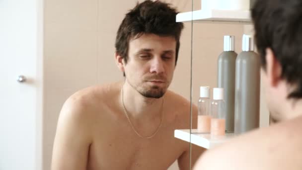 Unavený muž, který se právě probudil se dívá na svůj odraz v zrcadle a překvapil. — Stock video
