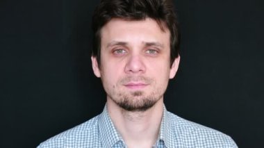 Sakal, anız, siyah arka plan üzerine temiz traşlı adam. Esmer hafif ekose gömlekli. Önden Görünüm.