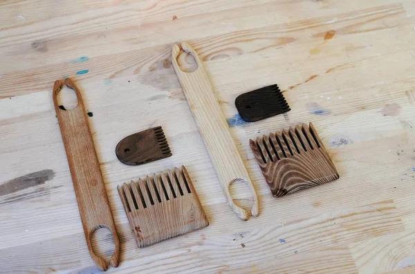 Инструменты гребешки и челноки на деревянном столе в мастерской . — стоковое фото