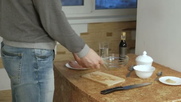 Un homme méconnaissable coupe la viande de poulet en gros morceaux . — Video