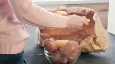 Tanınmayan kadın Soyma patates. Yan görünüm.