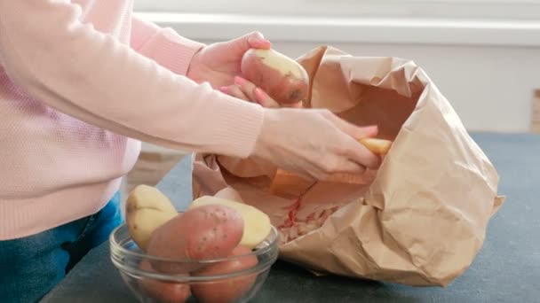 Onherkenbaar vrouw peeling aardappelen. Zijaanzicht — Stockvideo