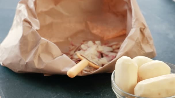 Closeup aardappelen in een kom. Geschilde aardappelen. Reinigings- en peeler in een eco-tas in de achtergrond. — Stockvideo