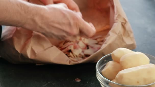 Skalad potatis i en skål. Mans händer rengöring potatis i en eco bag i bakgrunden. — Stockvideo