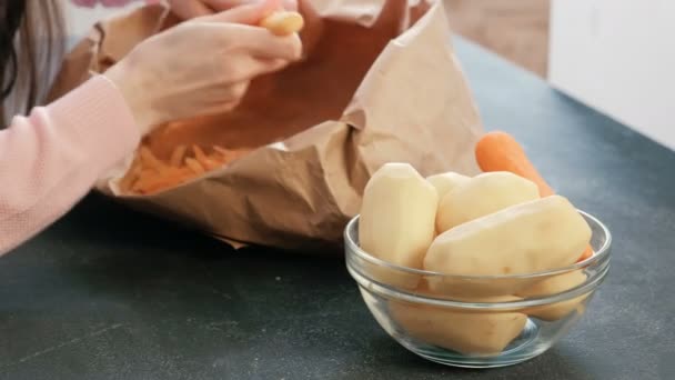 Primeros planos de las mujeres manos pelando zanahoria y ponerlo en el plato . — Vídeo de stock