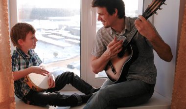 Bir enstrüman çalma. Baba gitar çalıyor ve son pencere içinde oturan tef çalacak.