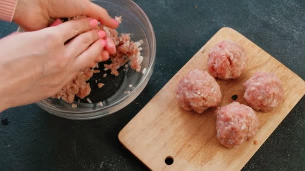 Close-up van een dames handen maken gehaktballen van gehakt vlees met rijst en zet het op een houten plank. Bovenaanzicht. — Stockvideo