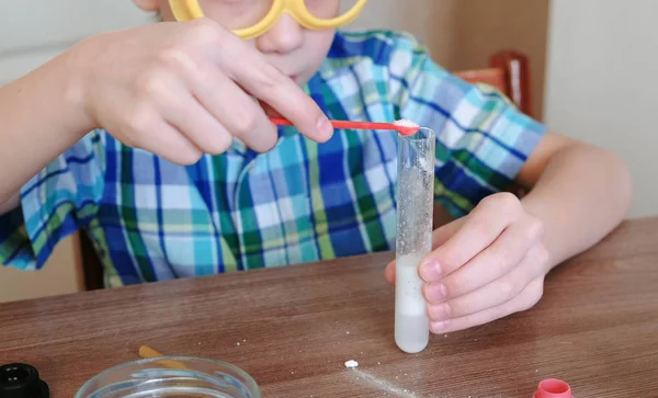 Experimentos de química en casa.Reacción química con la liberación de gas en el tubo de ensayo en las manos del niño . —  Fotos de Stock