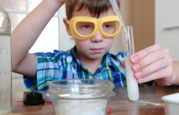 Experimentos de química en casa. Boy Vierte el agua para probar el tubo usando la pipeta . — Foto de Stock