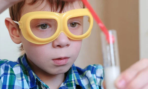 Expériences en chimie à la maison. Garçon regarder la réaction chimique avec le dégagement de gaz dans le tube à essai chez le garçon, mains s . — Photo