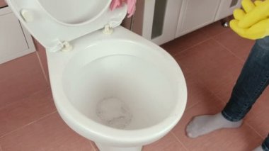 Sarı lastik eldiven eller kadının tuvalete pembe bez ile yıkayın.