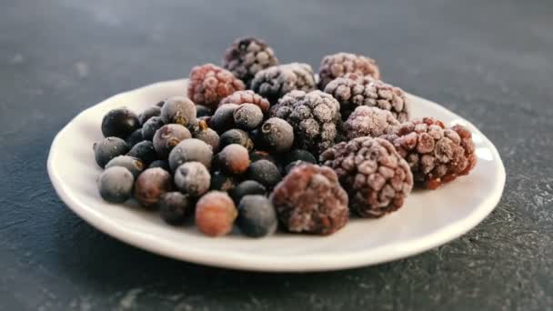 Замороженные ягоды на белой блюдце BlackBerry и черная смородина . — стоковое видео