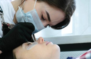 Şevval Özçelik Güzellik kirpikleri bir iğneyle ayırır ve onları curlers virajlı. Botox ve kirpik laminasyon. Closeup görünümü.