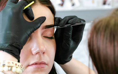 Güzellik uzmanı cımbız ile düzeltme kaş yordam gerçekleştirir. Açık closeup görünümü.