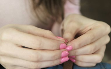 Yakın çekim elinde iğne iplik harcayan genç bir terzi.