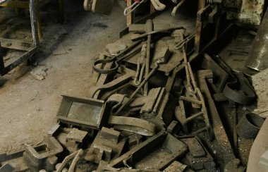 Yerdeki demirci dükkanında hurda metal yığını.