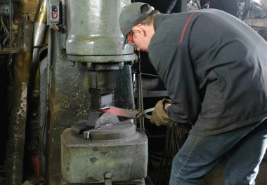 Bıçak dışarı metal demirhane, yapma. Çekiçleri şekil sıcak metal için kullanan adam.