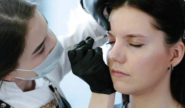 Cosmetólogo realiza el procedimiento de corrección de cejas con pinzas. Vista de cerca . —  Fotos de Stock